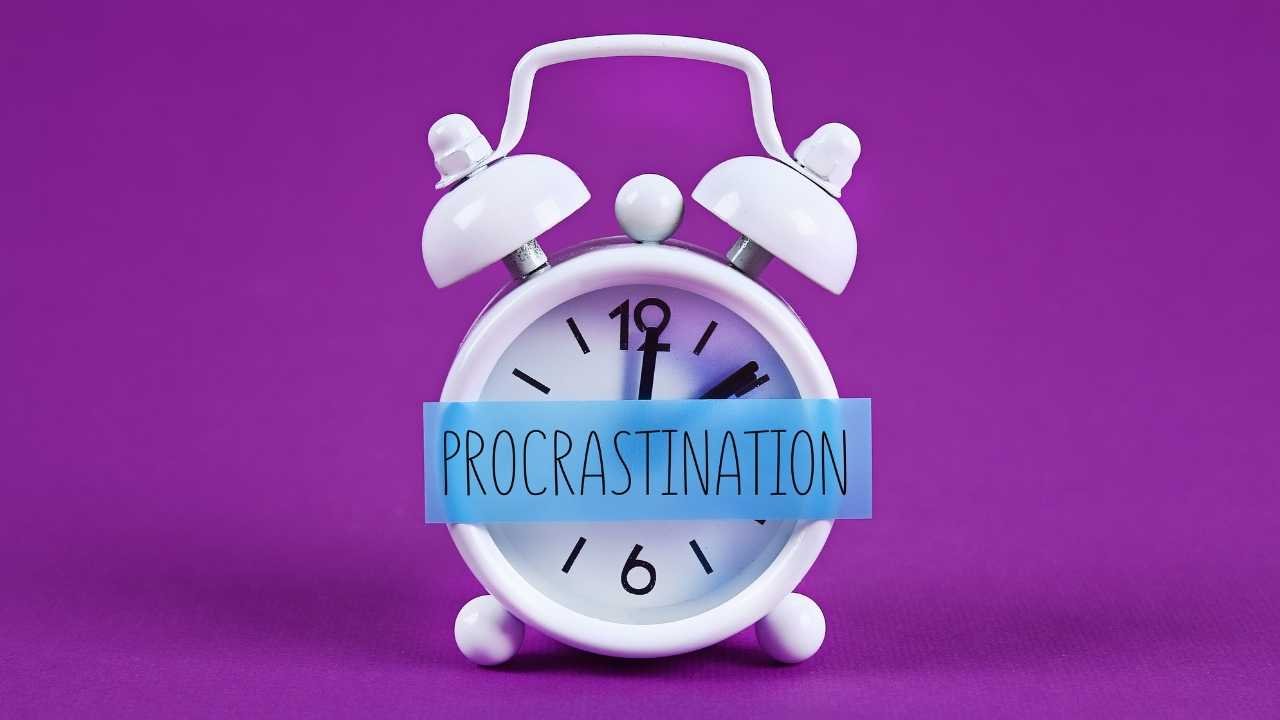 Procrastination written on a paper and pasted on a clock.